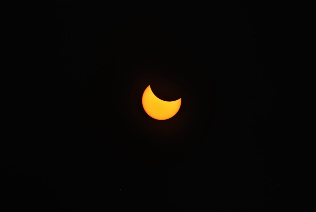 A photo of a solar eclipse with the sun partly obscured